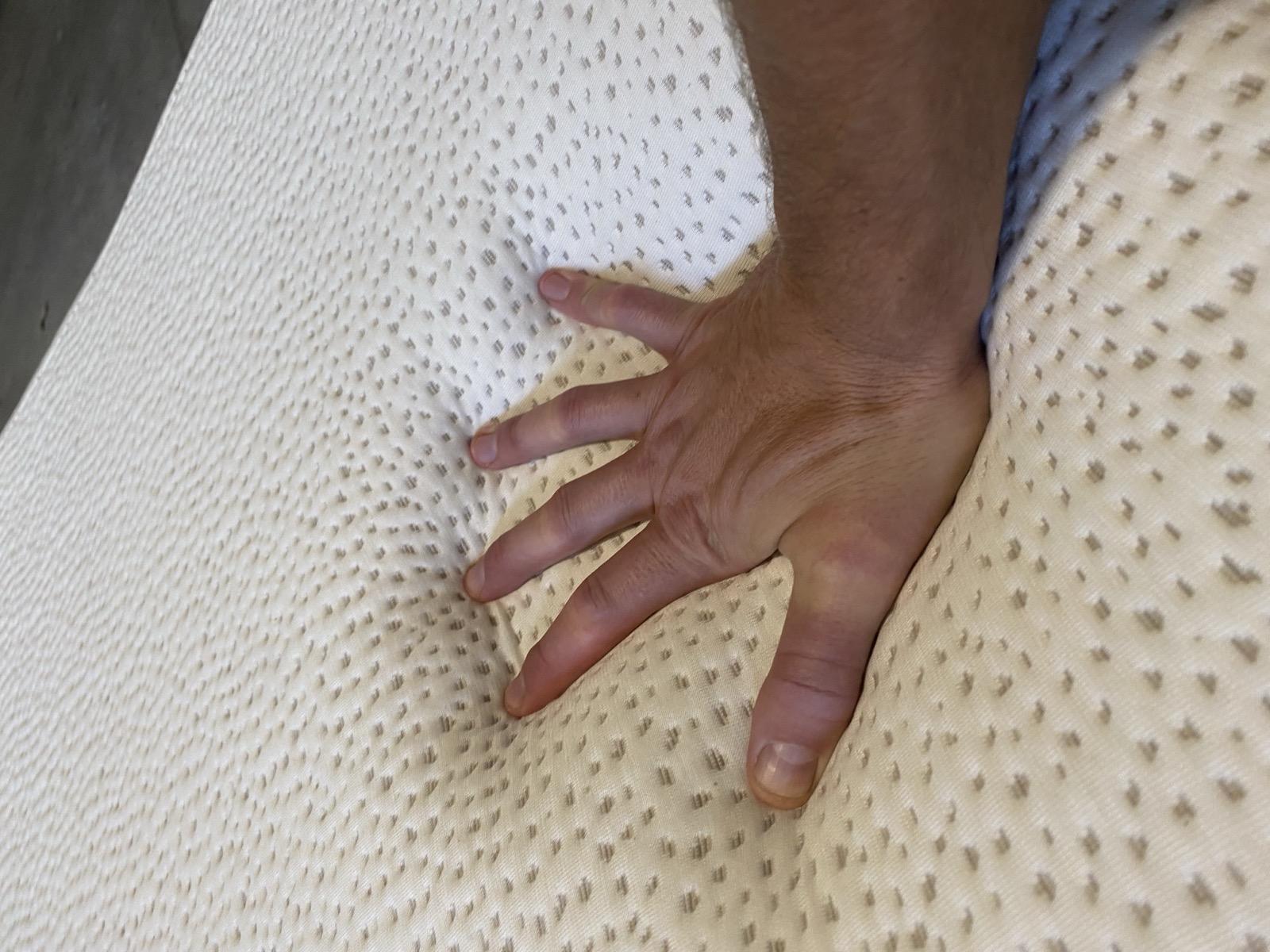 Testing memory foam feel by pressing hand into 5 Little Monkeys mattress